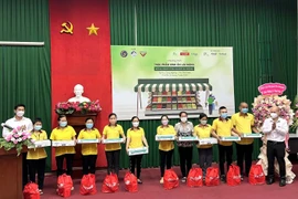 Lãnh đạo Ban Quản lý các khu chế xuất, khu công nghiệp Thành phố Hồ Chí Minh và Sở Công Thương thành phố tặng quà cho công nhân, người lao động có hoàn cảnh khó khăn. (Ảnh: TTXVN)