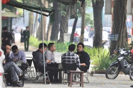 Một quán càphê trên phố Trần Hưng Đạo kinh doanh lấn chiếm vỉa hè, để khách ngồi không đảm bảo khoảng cách phòng dịch. (Ảnh: Hoàng Hiếu/TTXVN) 