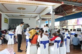 Lực lượng chức năng phường Tân Phú (thành phố Đồng Xoài) lập biên bản ghi nhận sự việc và hướng dẫn khai báo y tế. (Ảnh: Đậu Tất Thành/TTXVN)