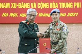 Thượng tướng Nguyễn Chí Vịnh, Thứ trưởng Bộ Quốc phòng trao Quyết định của Chủ tịch nước cho Trung tá Trần Đức Hưởng đi thực hiện nhiệm vụ tại Trụ sở Liên hợp quốc (tại New York, Hoa Kỳ). (Ảnh: Dương Giang/TTXVN)