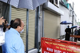 Chủ tịch nước Nguyễn Xuân Phúc thăm hỏi nhân dân trong khu vực phong tỏa tại thị trấn, Hóc Môn, huyện Hóc Môn. (Ảnh: Thống Nhất/TTXVN) 