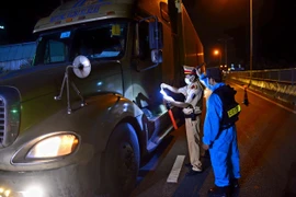 Công an TP.HCM làm nhiệm vụ tại chốt kiểm soát trên Quốc lộ 1K (giáp ranh tỉnh Bình Dương). (Ảnh: Thành Chung/TTXVN)
