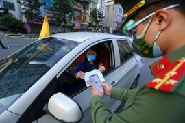 Lực lượng trực chốt cầu Vĩnh Tuy kiểm tra mã QR trên giấy đi đường của người dân sáng 8/9. (Ảnh: Hoàng Hiếu/TTXVN) 