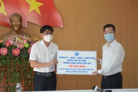 Bí thư Thành ủy Đà Nẵng Nguyễn Văn Quảng trao số tiền thưởng nóng cho đại diện quận Sơn Trà. (Ảnh: Văn Dũng/TTXVN)