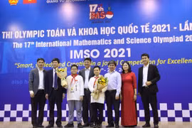 Đại diện Sở Giáo dục và Đào tạo Hà Nội tặng hoa chúc mừng hai học sinh giành huy chương vàng. (Ảnh: Báo Giáo dục và Thời đại)