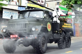 Lực lượng phòng hóa quân đội triển khai các phương tiện kỹ thuật tiến hành phun khử khuẩn diện rộng trên địa bàn quận Gò Vấp. (Ảnh: TTXVN phát) 
