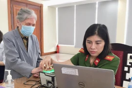 Cán bộ Đội 2, Phòng Cảnh sát quản lý hành chính về trật tự xã hội (Công an thành phố Hà Nội) phục vụ người dân đến làm thẻ căn cước công dân gắn chíp. (Ảnh: Nguyễn Thắng/TTXVN)