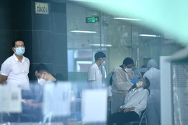 Lực lượng y tế lấy mẫu sàng lọc SARS-CoV-2 cho những người trong tòa D, Bệnh viện Việt Đức chiều 30/9. (Ảnh: Hoàng Hiếu/TTXVN) 