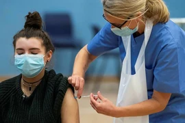 Nhân viên y tế tiêm vaccine ngừa COVID-19 cho người trẻ tuổi ở London, Anh. (Ảnh: Getty Images/TTXVN)