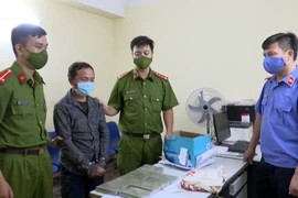 Đối tượng Giàng Bả Dế và tang vật tại cơ quan công an. (Ảnh: TTXVN phát) 