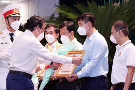 Ông Nguyễn Văn Nên, Ủy viên Bộ Chính trị, Bí thư Thành ủy Thành phố Hồ Chí Minh, trao Bằng khen của UBND thành phố cho đại diện các tập thể có thành tích xuất sắc trong hỗ trợ công tác phòng, chống dịch COVID-19. (Ảnh: Xuân Khu/TTXVN)