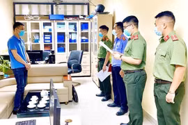 Cơ quan chức năng tiến hành tạm giữ và khám xét nơi làm việc của các đối tượng. (Ảnh: Thái Thuần/TTXVN)