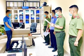Cơ quan chức năng tiến hành tạm giữ và khám xét nơi làm việc của các đối tượng. (Ảnh: Thái Thuần/TTXVN)