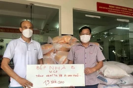 Đại diện nhóm Bếp từ thiện Nhà B ủng hộ thực phẩm đến Ủy ban Mặt trận Tổ quốc Việt Nam phường An Phú (thành phố Thủ Đức, Thành phố Hồ Chí Minh). (Ảnh: Hồng Giang/TTXVN)