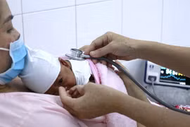 Bác sỹ thăm khám cho bệnh nhi. (Ảnh: TTXVN phát)