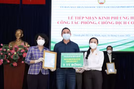 Bà Phan Kiều Thanh Hương, Phó Chủ tịch Ủy ban Mặt trận Tổ quốc Việt Nam Thành phố (bên phải) tiếp nhận bảng tượng trưng ủng hộ công tác phòng, chống dịch COVID-19 của Ban Liên lạc truyền thồng Trường Sơn, Thành phố Hồ Chí Minh. (Ảnh: Xuân Khu/TTXVN)