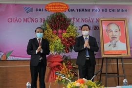 Bí thư Trung ương Đảng, Trưởng ban Tuyên giáo Trung ương Nguyễn Trọng Nghĩa tặng hoa chúc mừng thầy cô giáo Đại học Quốc gia Thành phố Hồ Chí Minh. (Ảnh: Thu Hoài/TTXVN)