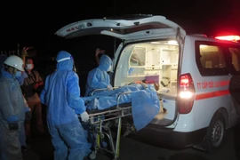 Ngư dân tàu cá Quảng Ngãi được đưa vào xe đi cấp cứu ở Bệnh viện Đa khoa tỉnh Khánh Hòa ngay khi vừa được đưa lên Cảng Nha Trang. (Ảnh: Phan Sáu/TTXVN)