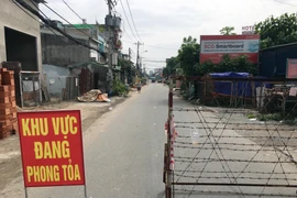 Lực lượng chức năng chốt chặn đầu đường TL19, đoạn giao đường Hà Huy Giáp (phường Thạnh Lộc, Quận 12, Thành phố Hồ Chí Minh). (Ảnh: Tiến Lực/TTXVN) 