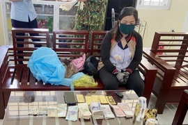 Đối tượng Huỳnh Thị Nguyên cùng tang vật bị bắt giữ phục vụ công tác điều tra. (Ảnh: TTXVN)