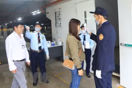 Đo nhiệt độ cho công nhân trước khi vào làm việc. Ảnh minh họa. (Ảnh: Hoàng Hùng/TTXVN)