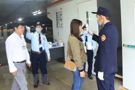 Đo nhiệt độ cho công nhân trước khi vào làm việc. Ảnh minh họa. (Ảnh: Hoàng Hùng/TTXVN)