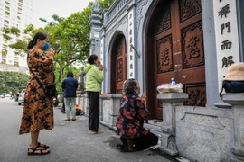 Người dân đến dâng hương, vái vọng ngoài cổng chùa Hà tuân thủ 5K đứng giãn khoảng cách. (Ảnh: Thành Đạt/TTXVN) 