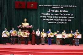 Trao Bằng khen của Chủ tịch UBND Thành phố Hồ Chí Minh cho đại diện các đoàn công tác y tế tăng cường tham gia hỗ trợ phòng, chống dịch COVID-19. (Ảnh: Xuân Khu/TTXVN)