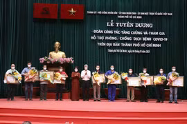 Trao Bằng khen của Chủ tịch UBND Thành phố Hồ Chí Minh cho đại diện các đoàn công tác y tế tăng cường tham gia hỗ trợ phòng, chống dịch COVID-19. (Ảnh: Xuân Khu/TTXVN)