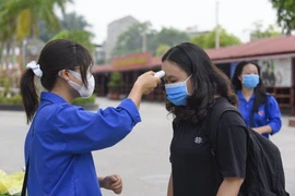 Các thí sinh ở Thanh Hóa đều được đo thân nhiệt trước khi vào khu vực thi. (Ảnh: Khiếu Tư/TTXVN)