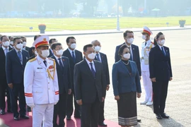 Chủ tịch Quốc hội Lào Xaysomphone Phomvihane cùng đoàn đại biểu cấp cao Quốc hội nước Cộng hòa Dân chủ Nhân dân Lào tưởng niệm Chủ tịch Hồ Chí Minh. (Ảnh: Văn Điệp/TTXVN) 