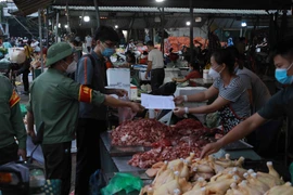 Tiểu thương tại chợ thường xuyên được tuyên truyền, nhắc nhở về việc thực hiện nghiêm các quy định về phòng chống dịch. (Ảnh: Vũ Sinh/TTXVN) 