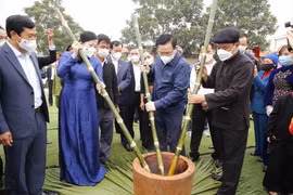Chủ tịch Quốc hội Vương Đình Huệ và các đại biểu cùng nhân dân giã bánh dày truyền thống. (Ảnh: Doãn Tấn/TTXVN) 