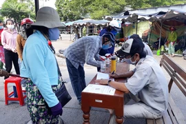 Người dân được kiểm tra thông tin, khai báo y tế trước khi vào chợ Thanh Sơn (phường Thanh Sơn, thành phố Phan Rang-Tháp Chàm) để phòng, chống dịch COVID-19. (Ảnh: Nguyễn Thành/TTXVN)