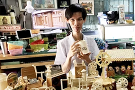 Anh Triệu Hồng Hồ Em cùng các sản phẩm thủ công từ tre. (Ảnh: Công Mạo/TTXVN) 