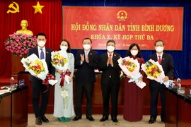 Ông Võ Văn Minh (thứ 4 từ trái qua), Phó Bí thư Tỉnh ủy, Chủ tịch UBND tỉnh Bình Dương, ông Phạm Văn Chánh (thứ 3 từ trái qua), Ủy viên Ban Thường vụ Tỉnh ủy, Chủ tịch HĐND tỉnh tặng hoa chúc mừng các đồng chí vừa trúng cử. (Ảnh: TTXVN phát)