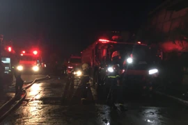 Lực lượng chức năng nỗ lực khống chế đám cháy. (Ảnh: Đỗ Trưởng/TTXVN)