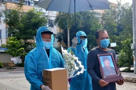 Con trai của bà N.T.H., khu vực 5, phường Hưng Thạnh, quận Cái Răng đón tro cốt bà về an nghỉ bên gia đình từ lực lượng quân đội. (Ảnh: Thu Hiền/TTXVN)