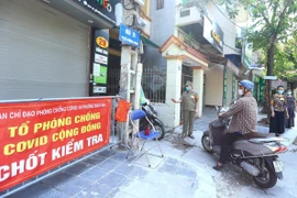 Tổ phòng, chống COVID cộng đồng thuộc tổ dân phố số 5, phường Bạch Mai, quận Hai Bà Trưng kiểm soát người dân ra, vào ngõ 29 Hồng Mai (ảnh chụp sáng 3/8). (Ảnh: Hoàng Hiếu/TTXVN) 