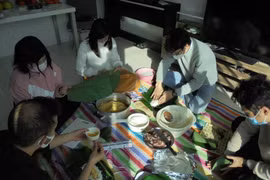 Gia đình anh Đỗ Minh Thịnh và bạn bè gói bánh chưng để chuẩn bị đón Tết. (Ảnh: Phạm Tuân/TTXVN)