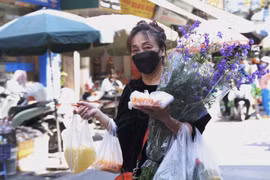 Người dân thủ đô mua hoa và những lễ vật để cúng tất niên và Giao thừa tại chợ Hàng Bè. (Ảnh: Hoàng Hiếu/TTXVN)
