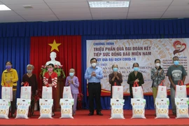 Ông Nguyễn Tiếc Hùng, Chủ tịch Ủy ban Mặt trận Tổ quốc Việt Nam tỉnh An Giang trao quà cho người dân gặp khó khăn do ảnh hưởng bởi dịch COVID-19 huyện Châu Thành. (Ảnh: Công Mạo/TTXVN)