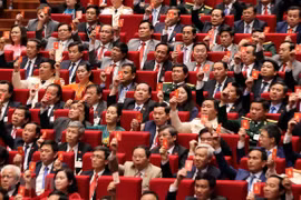 Các đại biểu biểu quyết, thông qua Nghị quyết Đại hội XIII Đảng Cộng sản Việt Nam. (Ảnh: TTXVN)