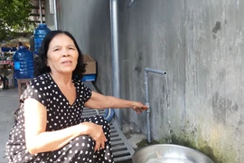 Bà Nguyễn Thị Nữ ở xã Bình Tường bị ngộ độc nên ngưng không sử dụng nước máy trong nhiều ngày nay mà chuyển sang dùng nước bình. (Ảnh: Tường Quân/TTXVN)