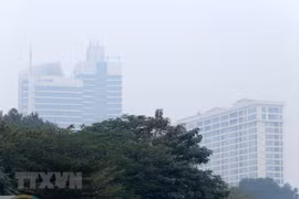 Các tòa nhà cao tầng chìm trong lớp sương mù, bụi mịn. (Ảnh: Hoàng Hiếu/TTXVN)