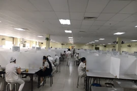 Tại Công ty trách nhiệm hữu hạn Kurabe hoạt động trong Khu công nghiệp Việt Nam-Singapore (VSIP1), các vách ngăn phòng ngừa dịch COVID-19 đã được thiết lập từ sớm. (Ảnh: TTXVN phát)