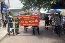 Lực lượng chức năng khẩn trương phong tỏa ổ dịch COVID-19 tại tổ 18, khu vực 4, phường Hải Cảng, thành phố Quy Nhơn. (Ảnh: Nguyên Linh/TTXVN)