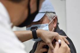 Nhân viên y tế tiêm vaccine phòng COVID-19 cho người dân tại Sydney, Australia. (Ảnh: AFP/TTXVN)