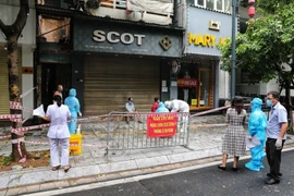 Lực lượng chức năng phường Lê Đại Hành tiến hành phong tỏa các số nhà từ 260 đến 266 phố Bà Triệu Sau khi có thông tin 2 ca dương tính với SARS-CoV-2 ở 264 phố Bà Triệu (Ảnh: Thành Đạt/TTXVN) 