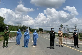 Tổ COVID-19 cộng đồng tại chốt kiểm soát xã Thường Tân, huyện Bắc Tân Uyên, tỉnh Bình Dương vui mừng sau khi toàn huyện đạt vùng xanh. (Ảnh: Chí Tưởng/TTXVN)